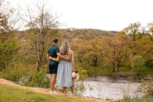 a man and a woman standing next to a river at Loch Awe Holiday Park in Taynuilt