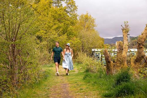 um homem e uma mulher a caminhar por um caminho em Loch Awe Holiday Park em Taynuilt