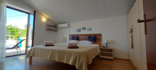 a bedroom with a large bed and a large window at Kuća Ugor in Lun