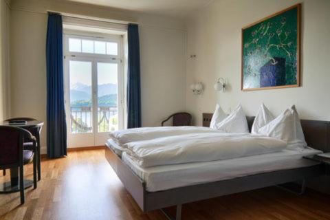 Un dormitorio con una cama grande y una ventana en Hotel Royal Luzern, en Lucerna