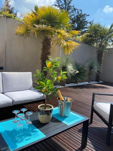 une table avec des verres et une plante sur une terrasse dans l'établissement Scorfel Lodge, Villa Matisse, Spa & terrasse, à Perros-Guirec