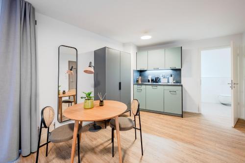 a kitchen and dining room with a table and chairs at limehome Metzingen Wilhelmstr in Metzingen