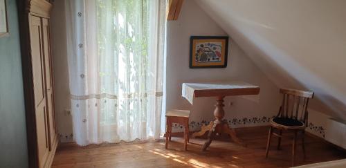 a room with a table and a staircase with a window at Mājīga istaba ar balkonu un vannasistaba, bezmaksas elektroauto uzlāde in Iecava