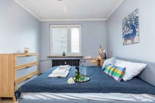 um quarto com uma cama azul com uma bandeja de comida em Serene Apartment in the City Center em Cracóvia
