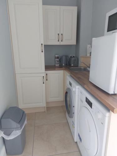 a kitchen with a washing machine and a sink at Grá na Farraige in Enniscrone