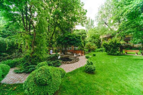 a garden with a bench and trees and grass at Sovinyon Resort in Odesa