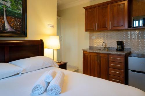 a bedroom with two beds and a kitchen with a sink at Villa Gumio Studio Apt - 7 minutes walk to Boca Chica Beach apts in Boca Chica