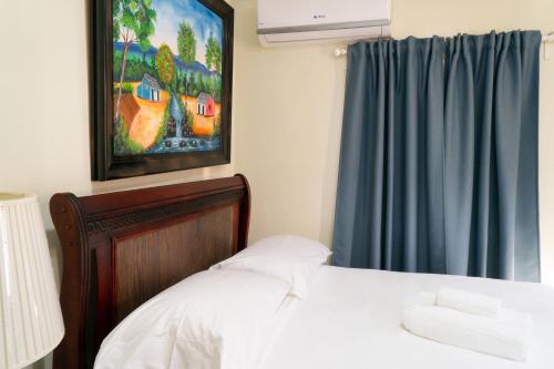 a bedroom with a bed and a painting on the wall at Villa Gumio 2BR Apt- 7 min walk to Boca Chica Beach apts in Boca Chica