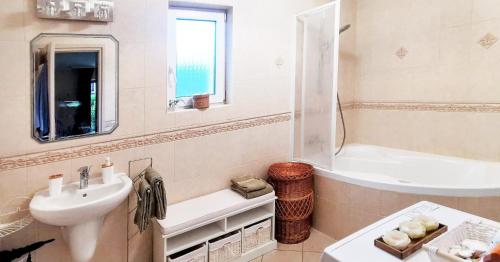 a bathroom with a sink and a bath tub and a sink at Mediterrania Apartment in Keszthely