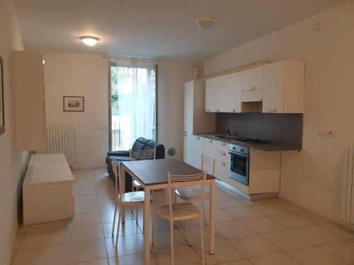 a kitchen and living room with a table and chairs at Appartamenti tra Lago e Montagna CASA IDEALE LECCO in Lecco