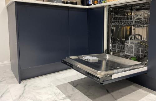 a metal dishwasher in a kitchen with a sink at The Leckhampton - Company and Family Stays Chester Road in Walsall