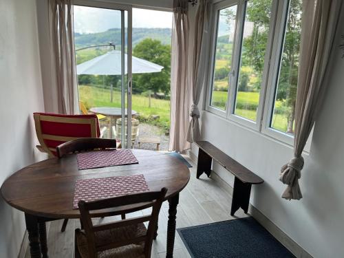 a dining room with a table and chairs and a window at Maison independante pour 2 tout inclus Tiny House for 2 all included in Teilhet
