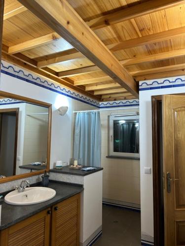 ein Badezimmer mit Waschbecken und Spiegel in der Unterkunft casa panorâmica bela vista in Angra do Heroísmo