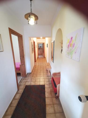 a hallway with a tile floor and a hallway with a room at Haus Luise in Krün