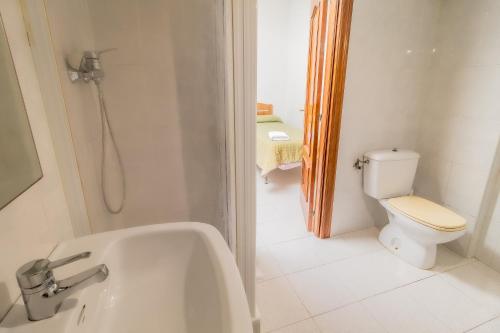 a bathroom with a toilet and a bath tub at Hostal - Restaurante La Buena Villa by Vivere Stays in Villalonquéjar