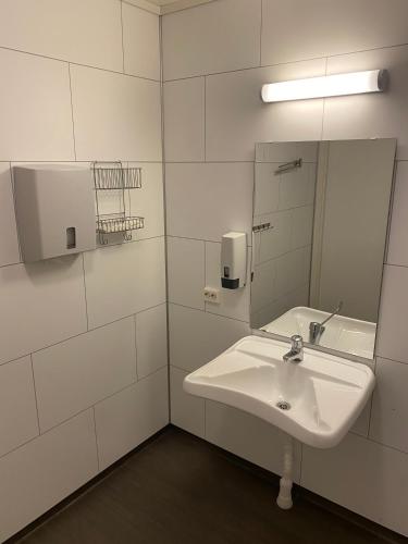a white bathroom with a sink and a mirror at Fjordly Ungdomssenter in Bryggja