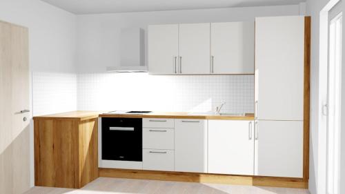 a kitchen with white cabinets and a black appliance at Ferienwohnung mit 125qm am Rande der Fußgängerzone in Sigmaringen in Sigmaringen