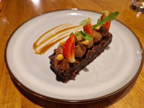 a piece of chocolate cake with fruit on a white plate at Clos De La Vaupalière - Rouen in La Vaupalière