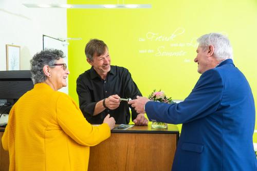 a man handing a woman a piece of jewelry at Hotel-Pension Haus Holtdirk in Lippstadt