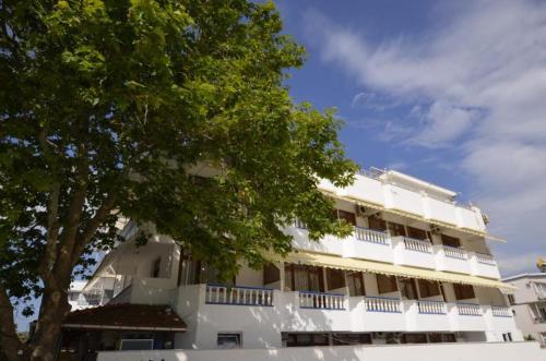 un edificio blanco con un árbol delante en ŞEREF APART MOTEL, en Marmara