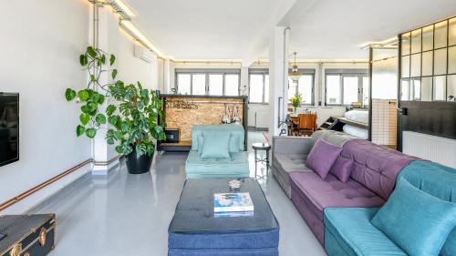 een woonkamer met een paarse bank en een tafel bij Monastiraki #WallsFree Experience- Unspoiled Athens Apartments in Athene