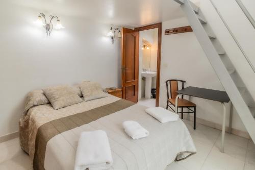 1 dormitorio con 1 cama, escalera y escritorio en Hostal - Restaurante La Buena Villa by Vivere Stays, en Villalonquéjar
