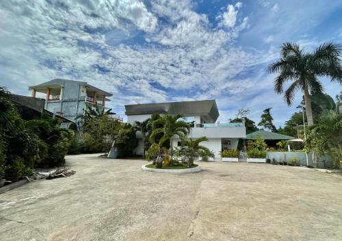 a white house with palm trees in front of it at Cheryl's Place Vacation Home Palawan in Puerto Princesa City