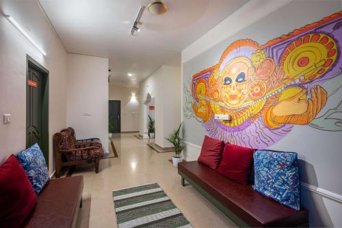 a living room with a large painting on the wall at Zostel Kochi, Fort Kochi in Cochin
