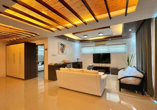 a living room with a white couch and a television at Cheryl's Place Vacation Home Palawan in Puerto Princesa City