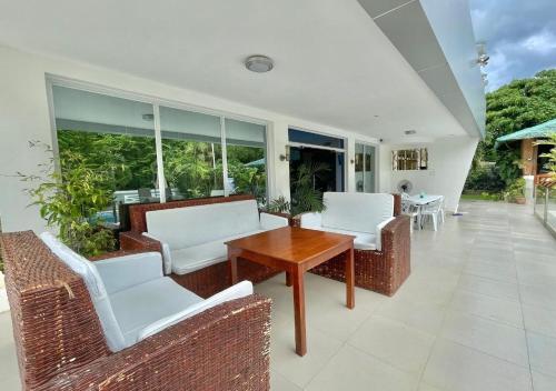 a patio with white chairs and a wooden table at Cheryl's Place Vacation Home Palawan in Puerto Princesa City