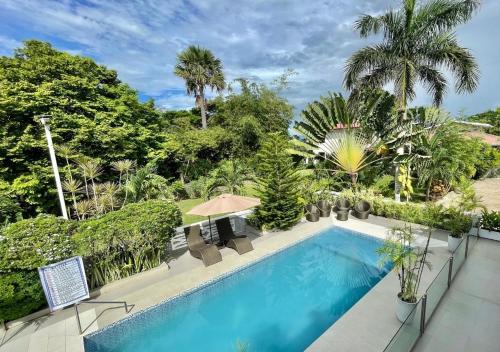 an overhead view of a swimming pool with chairs and trees at Cheryl's Place Vacation Home Palawan in Puerto Princesa City