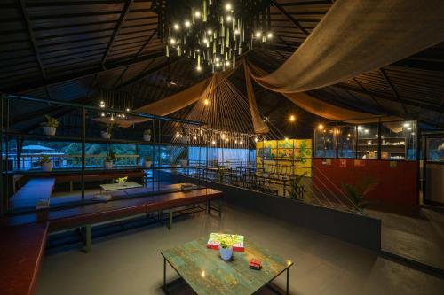 ein Restaurant mit Tischen und Kronleuchtern in einem Zimmer in der Unterkunft Zostel Kochi, Fort Kochi in Kochi