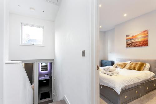 een witte slaapkamer met een bed en een raam bij Stunning Modern two bedroom flat near Notting hill Gate in Londen