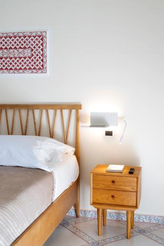 a bedroom with a bed and a table with a lamp at B&B Marcantonio - Ischia Ponte in Ischia