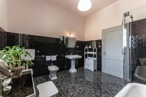 a bathroom with a sink and a toilet and a mirror at Villa Clementina - Prosecco Country Hotel in San Pietro di Feletto