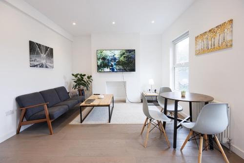 een woonkamer met een bank en een tafel bij Stunning Modern two bedroom flat near Notting hill Gate in Londen