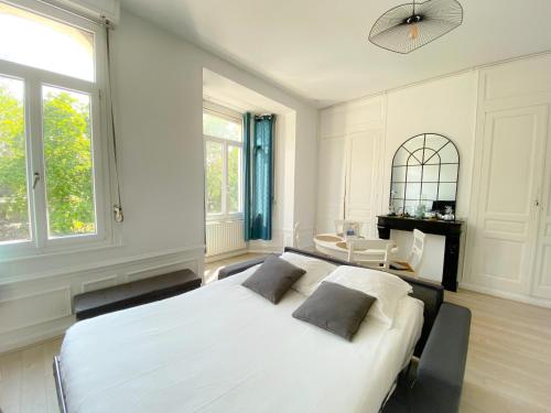 Un dormitorio blanco con una cama grande y una mesa en Le Saint Pierre en Calais