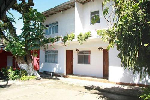 una casa blanca con un banco delante en Pousada Cirandinha, en Itajaí