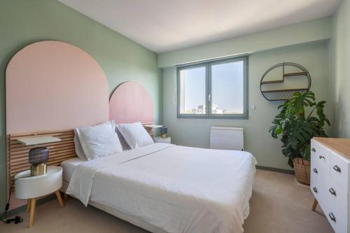 una camera da letto con un grande letto bianco e una pianta di City Escape a Le Bourget