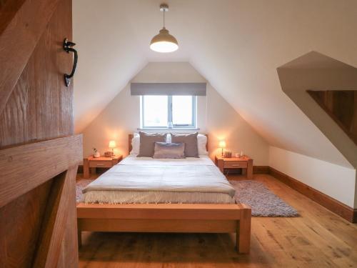 um quarto com uma cama grande num sótão em Postbox Cottage em Ashbourne