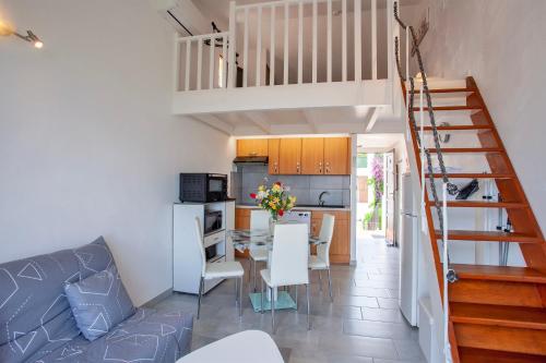 Il comprend un salon et une cuisine avec une table et des chaises. dans l'établissement San Lucianu - Appt vue mer et montagne, à LʼÎle-Rousse