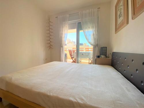 a large bed in a bedroom with a window at Gemelos 22-1-5 in Benidorm