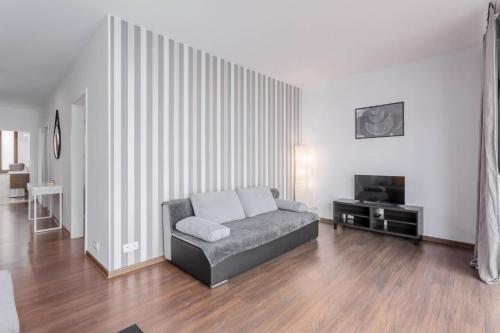 a living room with a couch and a television at Chill Apartments Bociania in Warsaw