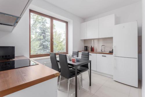 a kitchen with a table and chairs in a kitchen at Chill Apartments Bociania in Warsaw