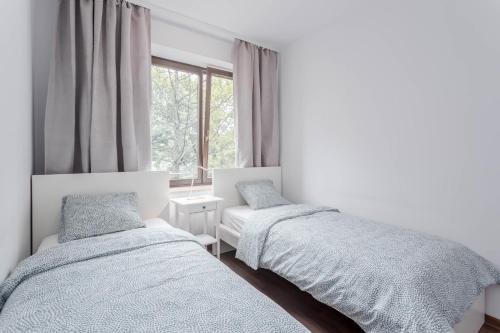 a bedroom with two beds and a window at Chill Apartments Bociania in Warsaw