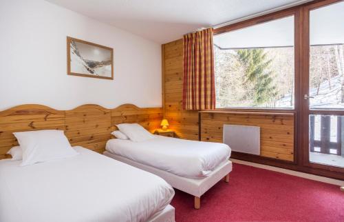 1 dormitorio con 2 camas y ventana en VVF La Plagne Montalbert Paradiski, en Aime La Plagne