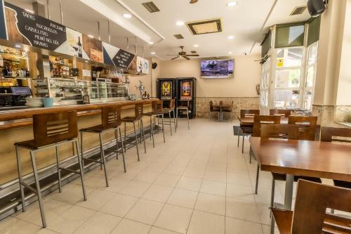 Un restaurante con mesas y sillas y un bar. en Hostal - Restaurante La Buena Villa by Vivere Stays, en Villalonquéjar