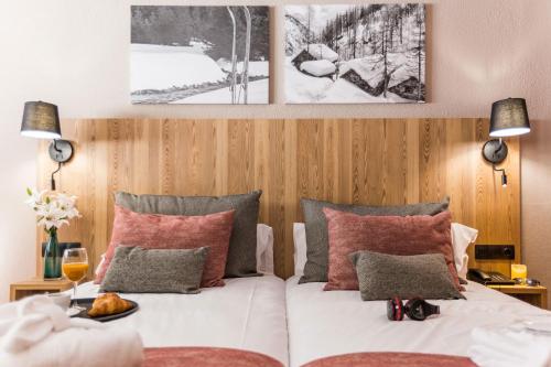 a bedroom with a bed with red and grey pillows at Hotel Grand Pas in Pas de la Casa