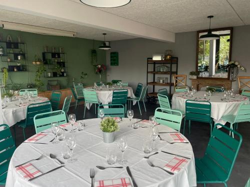 a dining room with white tables and green chairs at Clos De La Vaupalière - Rouen in La Vaupalière