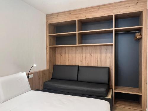 um quarto com uma cama e uma estante de livros em YUGOGO MAZZINI 41 - BILOCALE Trento Centro em Trento